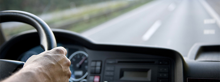 Blick vom Beifahrersitz eines fahrenden Autos aus auf das Cockpit und die Fahrbahn.