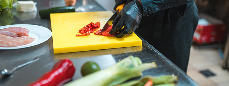 Jemand schneidet Gemüse in einer Küche.